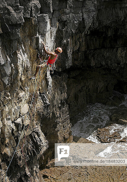 Man rock climbing on sunny day  Pembrokeshire  Wales