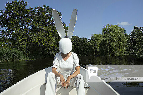 Frau mit Hasenmaske sitzt im Boot