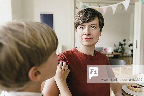 Serious woman with son at home
