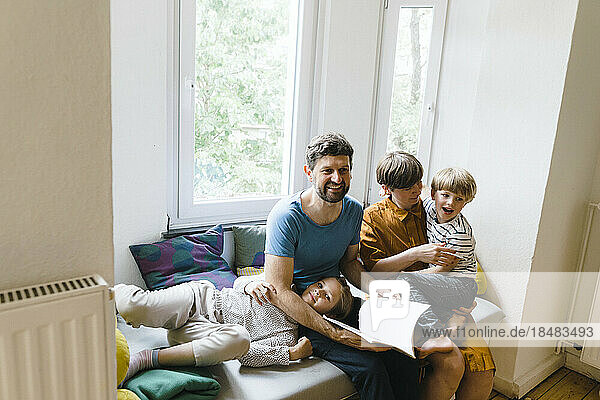 Happy family enjoying together sitting on seat at home