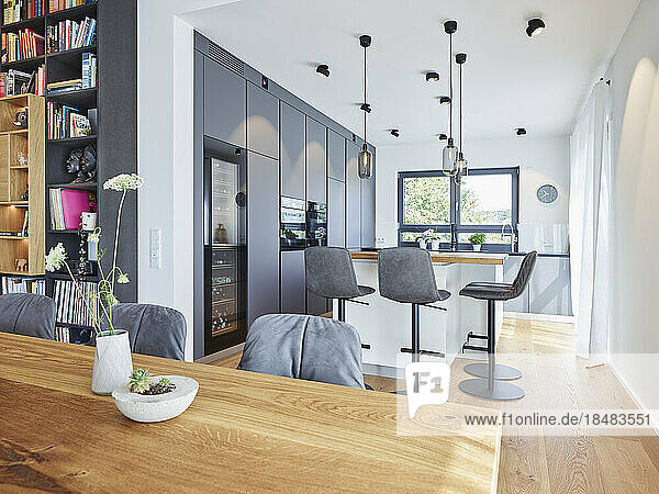 Dining table with kitchen in background at modern apartment