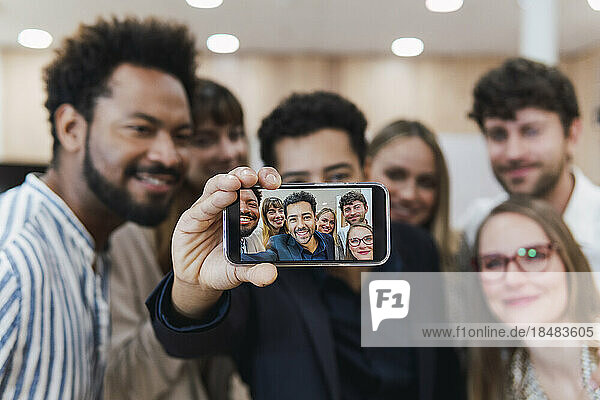Happy business team taking a selfie in office