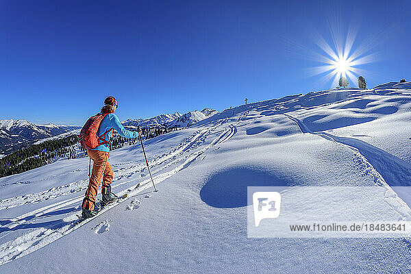 Austria  Tyrol  Female skier ascending snowcapped slope of Schonbichl