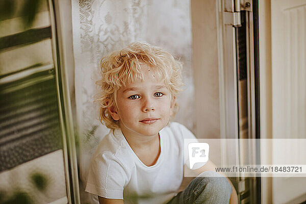 Cute boy sitting at doorway of camper van