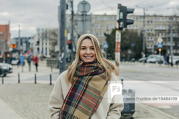 Smiling woman wearing warm clothing at street