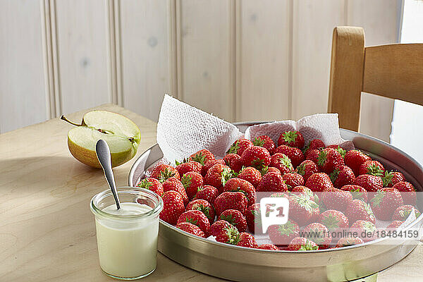Fresh ripe strawberries and jar of yogurt