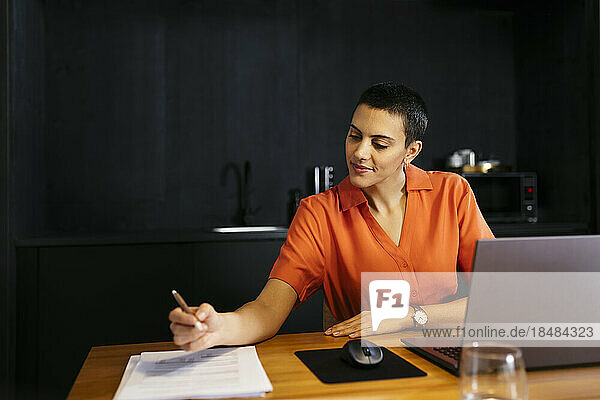 Smiling freelancer looking at document at table
