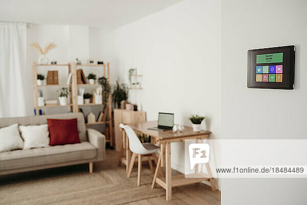 Modernes Wohnzimmer mit Möbeln und Hausautomations-App auf Tablet-PC