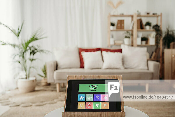 Home automation app on tablet PC in modern living room at home