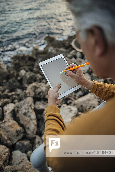 Senior man using tablet PC with digitized pen