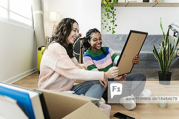Happy women looking at photo frame at home