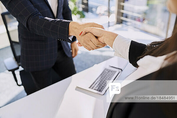Personalvermittler und Kandidat beim Händeschütteln nach dem Vorstellungsgespräch im Büro
