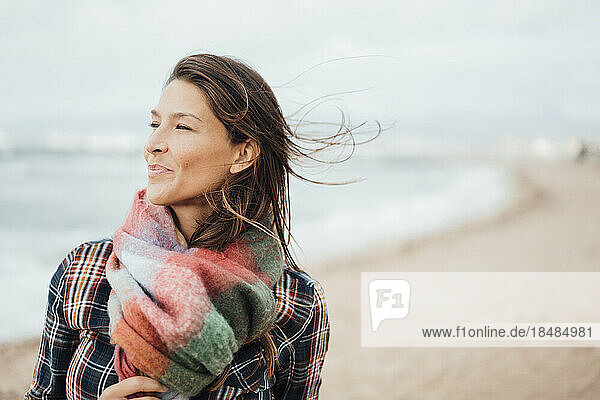 Smiling woman with scarf at beach