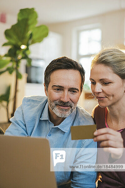 Husband and wife doing home shopping through credit card at home