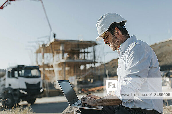 Architect using laptop at construction site