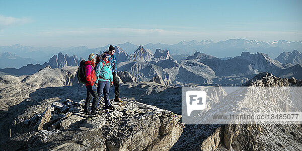 Freunde stehen an einem sonnigen Tag am Berg Piz Boe  Dolomiten  Italien