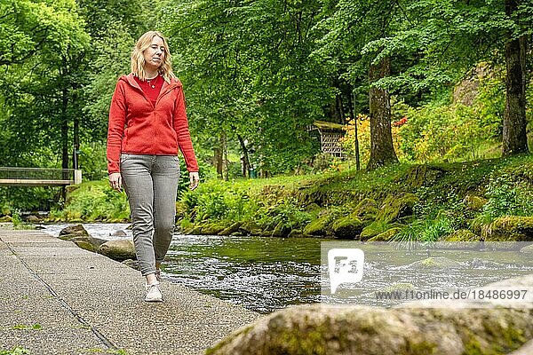 Woman running on the banks of the En river in the spa garden  Bad Wildbad  Black Forest  Germany  Europe
