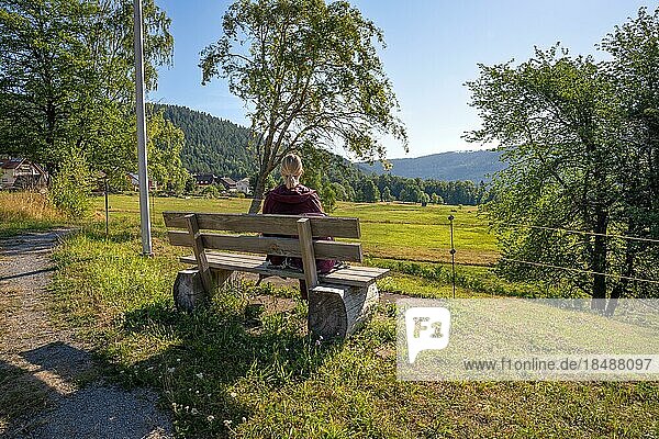 Woman sitting on bench and looking into the distance  Sprollenhäuser Hut  Bad Wildbad  Black Forest  Germany  Europe
