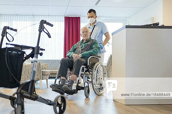 Pfleger mit Mann im Rollstuhl im Pflegeheim  Heidelberg  Deutschland  Europa