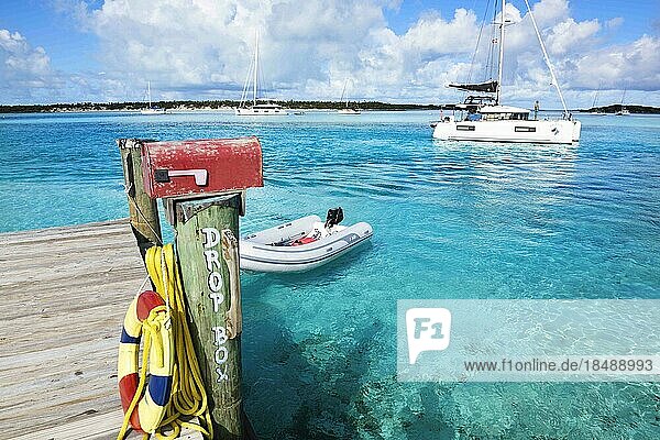 Landesteg und Briefkasten der Warderick Wells  im Hintergrund eing Segelkatamaran  Bahamas and Exuma Cays Land and Sea Nationalpark  Bahamas  Mittelamerika