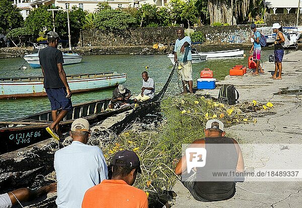 Fischer auf der Kaimauer  reparieren nach ihrem nächtlichen Fang wieder ihre Netze  Trou dEau Douce  Mauritius  Afrika