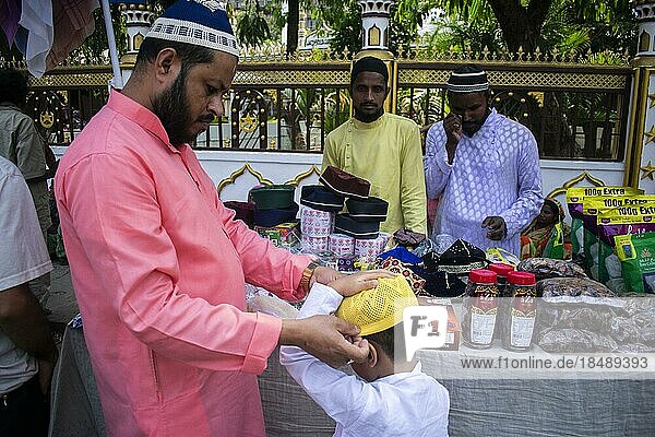 Ein indischer muslimischer Vater kauft eine Mütze für seinen Sohn  bevor er das zweite Freitagsgebet im heiligen Monat Ramadan in einer Moschee in Guwahati  Indien am 31. März 2023 verrichtet