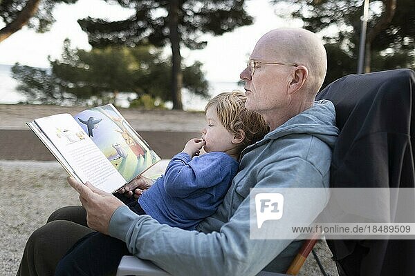 Thema: Großvater und Enkelkind lesen ein Buch.  Seget Vranjica  Kroatien  Europa