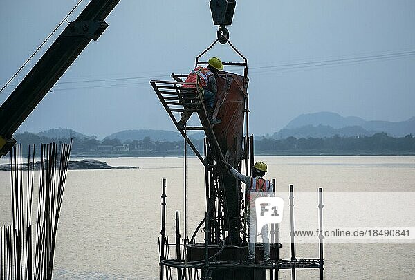 Construction workers busy build pillars of a bridge in the banks of Brahmaputra river on April 3  2023 in Guwahati  Assam  India  Asia