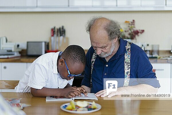 Großeltern auf Zeit. Großvater betreut ehrenamtlich für einige Stunden in der Woche einen Jungen aus Afrika.  Bonn  Deutschland  Europa