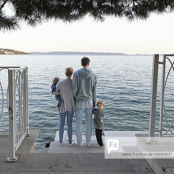 Family standing by the sea  Seget Vranjica  Croatia  Europe