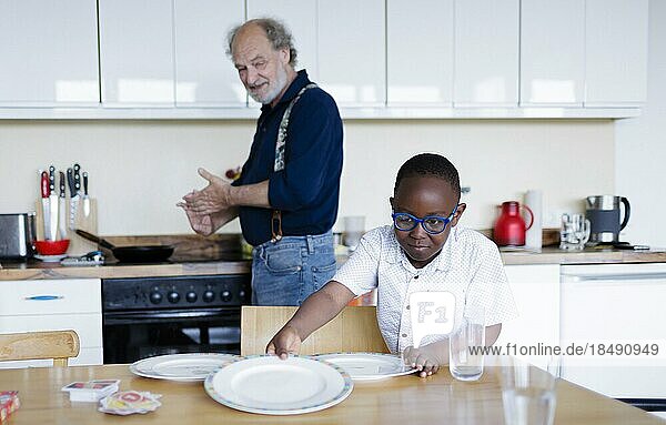 Großeltern auf Zeit. Älterer Mann betreut ehrenamtlich für einige Stunden in der Woche einen Jungen aus Afrika.  Bonn  Deutschland  Europa