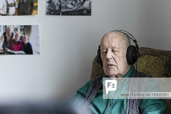 Old man in nursing home listening to music with headphones. Old man in nursing home listening to music with headphones.  Heidelberg  Germany  Europe