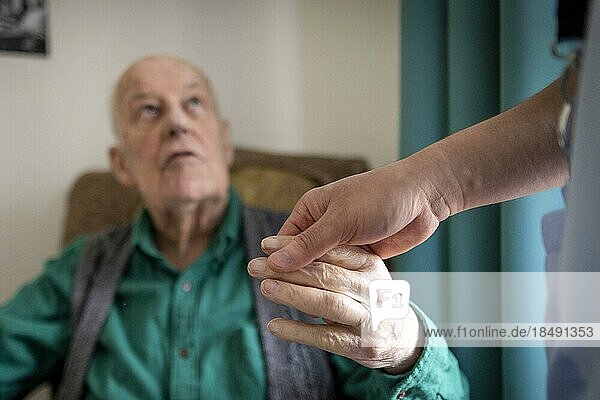 Geriatric nurse holding the hand of an old man in a nursing home  Heidelberg  Germany  Europe