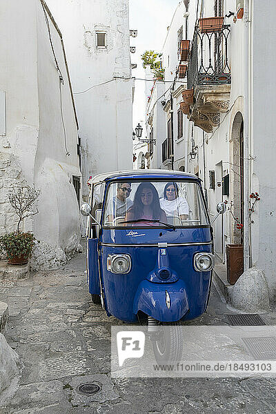 Blaues Touristen-Tuk-Tuk beim Sightseeing durch die engen Gassen der alten weißen Stadt  Ostuni  Provinz Brindisi  Apulien  Italien  Europa