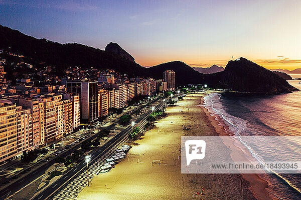 Aerial drone view of Leme Beach in the Copacabana district at sunrise with the iconic Sugarloaf Mountain in the background  UNESCO World Heritage Site  Rio de Janeiro  Brazil  South America