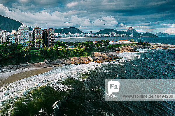 Aerial drone view of Arpoador section of Ipanema Beach with Copacabana and Sugarloaf Mountain visible in the background  Rio de Janeiro  Brazil  South America