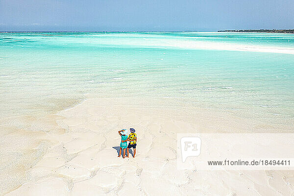 Cheerful man and woman embracing on idyllic tropical beach  overhead view  Nungwi  Zanzibar  Tanzania  East Africa  Africa