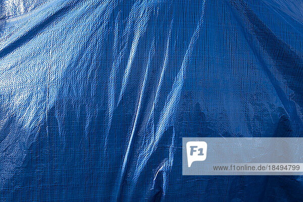 A blue tarpaulin covering a hidden object.