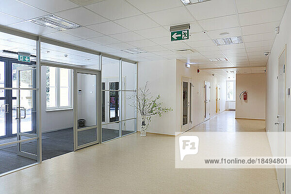A modern school building  a wide corridor and hallway  light and airy  glass doors.