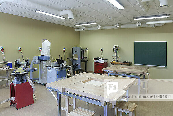 School classroom set up for a technical or practical course. Woodworking and light engineering. Clamps  machines and work surfaces.