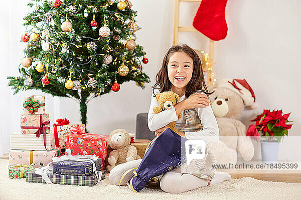 Smiling young girl opening Christmas presents