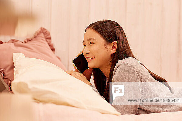 Japanese girl with smartphone in bed