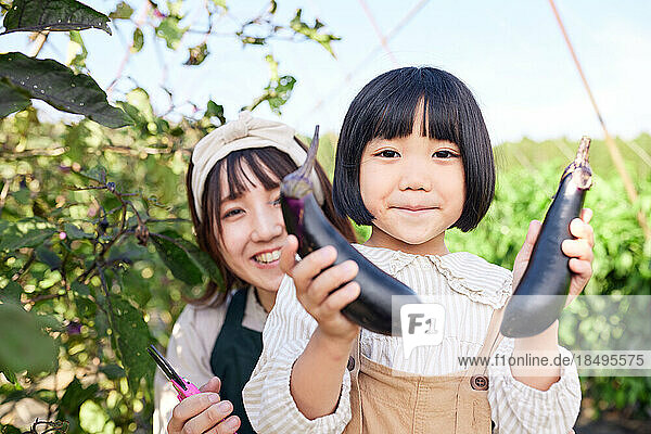 Japanese mum and kid working at vegetable garden