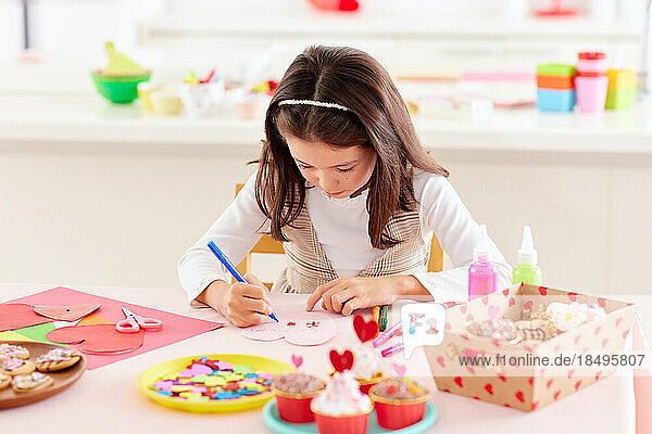 Smiling young girl playing with craft paper
