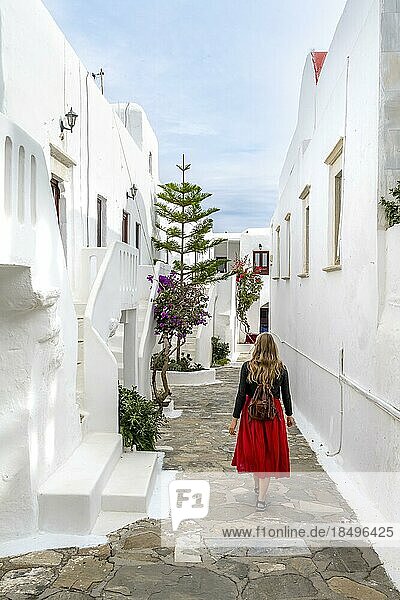 Young woman with red skirt in the alleys of Ano Mera  Cycladic white houses  Ano Mera  Mykonos  Cyclades  Greece  Europe