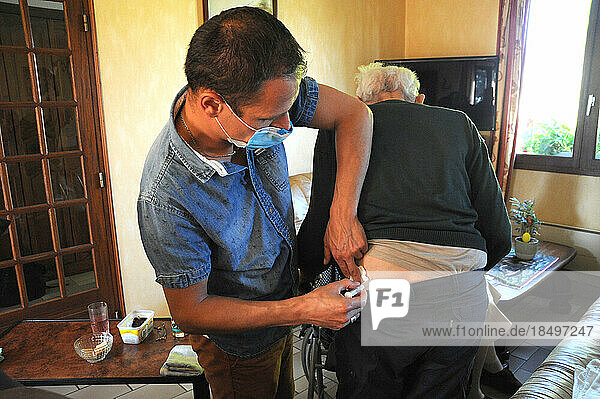 Liberal country nurse at a patient's home for an intramuscular injection of ceftriaxone  antibacterial antibiotics for a urinary tract infection.