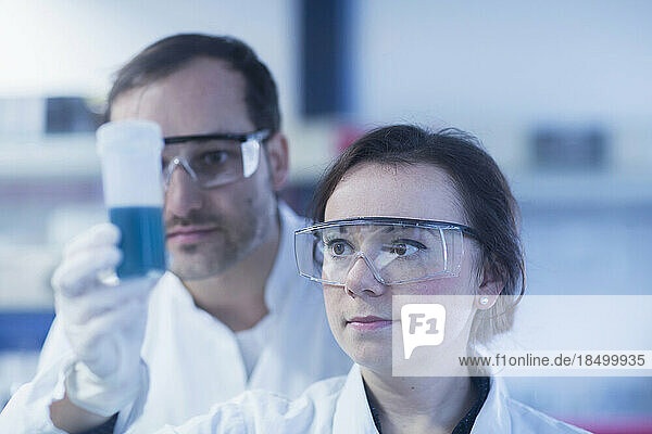 Young scientists examining test tube in a laboratory  Freiburg Im Breisgau  Baden-wuerttemberg  Germany