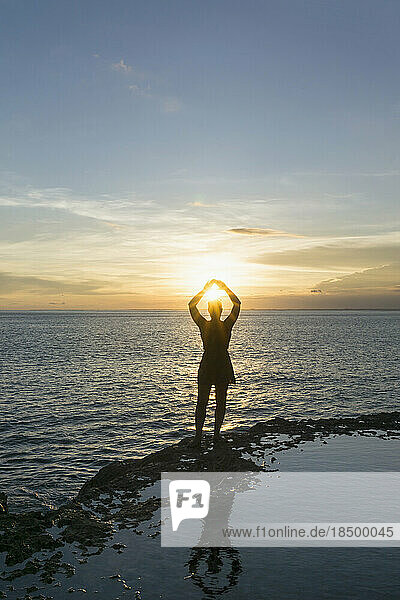 Silhouette of a woman gesturing against sun during sunset on beach  Nusa lembongang  Bali  Indonesia