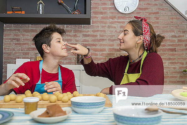 Brothers playing with dough and flour while working on pastry at