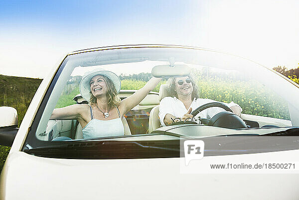 Happy couple driving in a car Beetle Cabrio  Bavaria  Germany
